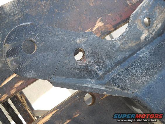 Cracked black metal bracket with two holes