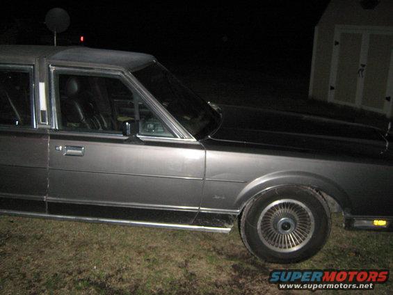 1980s Lincoln Town Car side view, dark exterior, parked at night
