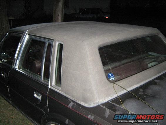 Car's vinyl top and rear window area. Another car is visible in the background