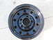 1986 Ford Bronco - Black steel wheel with 5x5.5 bolt pattern shown on concrete.