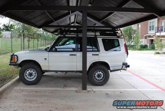 White 1999 Land Rover Discovery II parked under a carport