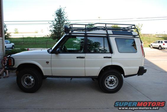 White 1999 Land Rover Discovery II with roof rack parked on concrete