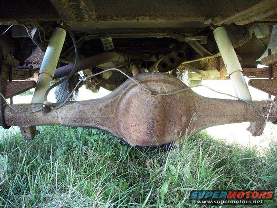 Rusty rear differential and white shock absorbers on an old truck, viewed from underneath