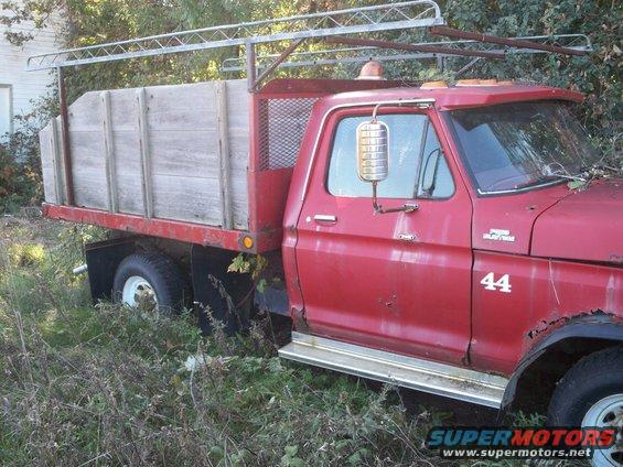 Red 1988 Ford F-150 flatbed truck with wooden sides and rack