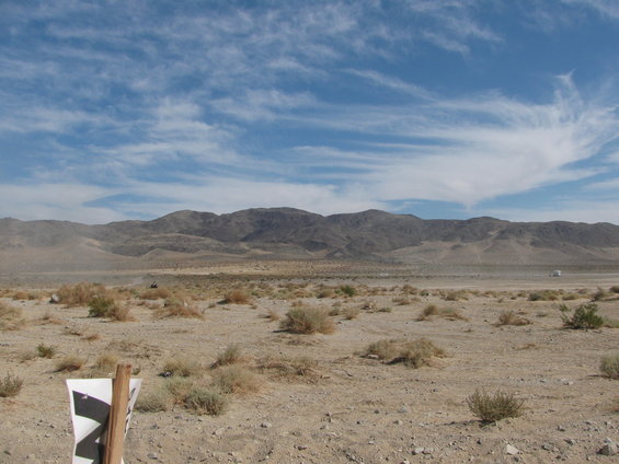 Desert landscape with distant white vehicle and a dirt bike