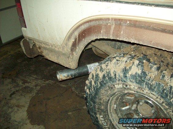 Exhaust pipe and muddy rear tire of a vehicle