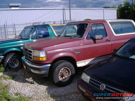 1992 Ford Bronco parked next to a green Ford Bronco