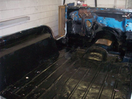 Interior of a vehicle with black painted floor and tub, blue firewall