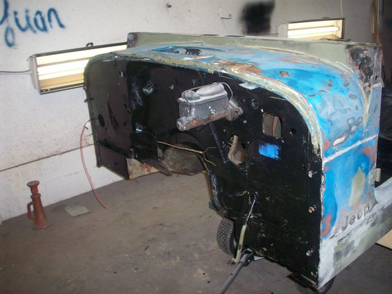 Jeep firewall and fender with blue and primer paint, showing brake master cylinder
