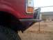 1989 Ford Bronco - Close-up of a red truck's front fender and custom bumper, with a tire visible.