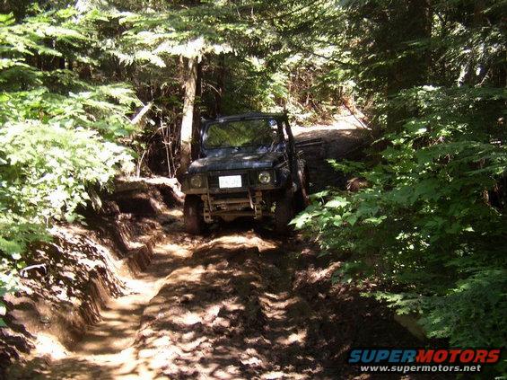 Black off-road vehicle on a muddy trail, front view