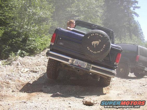 Ford Bronco on dirt trail, spare tire cover says Ford Bronco. License plate GNJ-057