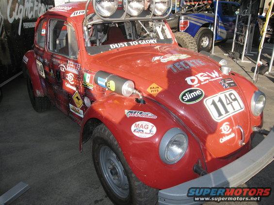 Red off-road Volkswagen Beetle with racing decals and roof lights