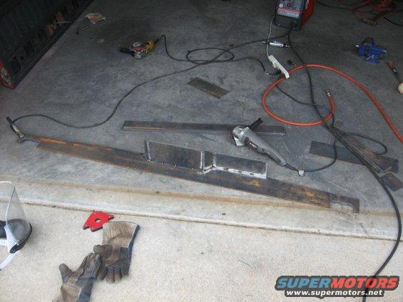 Metal pieces and welding equipment on a concrete floor