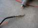 1995 Ford F-150 - A metal rod, possibly a shifter linkage, lies on a concrete surface next to an air tool.