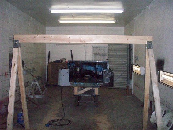 Jeep CJ5 body on stand, interior visible, in garage