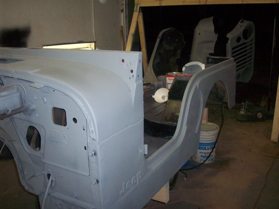 Gray primer Jeep CJ5 body, side view, showing "Jeep" script on the rocker panel