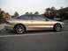 1990 Ford Escort - Side view of a gold Ford Probe GT with aftermarket wheels and a rear spoiler.