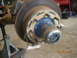 1991 Ford F-150 - This image shows a close-up of a vehicle's hub and brake rotor assembly, supported by a jack stand.