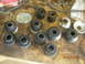 1991 Ford F-150 - Various vehicle suspension bushings and washers are laid out on a wooden surface, possibly for replacement or repair.
