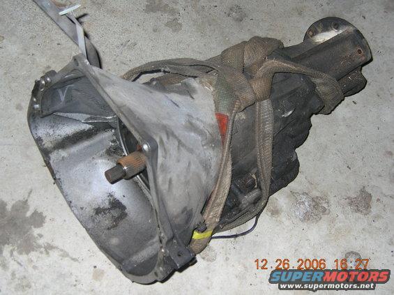 Transmission assembly with straps, resting on concrete floor. Date stamp shows 12.26.2006