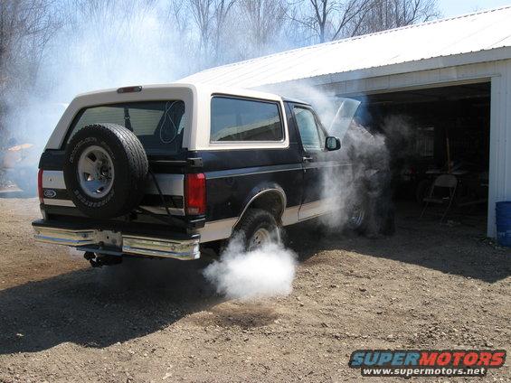 1992 Ford Bronco with hood open, emitting white smoke from exhaust and engine bay
