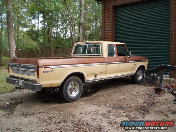 Two-tone brown and tan 1975 Ford F-250 parked in front of a garage