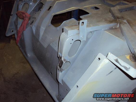 Gray vehicle body part with red rag, Supermotors logo visible