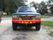 1992 Ford Explorer - The front of a teal 1992 Ford Explorer is shown with a custom red bull bar and KC lights.