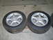 1993 Ford Probe - A pair of used car wheels and tires are shown resting on a garage floor.