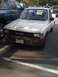 1989 Toyota Pickup/SR5 - A white 1989 Toyota Pickup/SR5 is parked in a lot, showing its front grille and headlights.