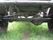 1973 Ford Bronco - The photo shows the undercarriage of a vehicle, focusing on the suspension and steering systems.