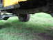 1973 Ford Bronco - The underside of a yellow vehicle shows its suspension and frame, with a "SUPERMOTORS" watermark visible.