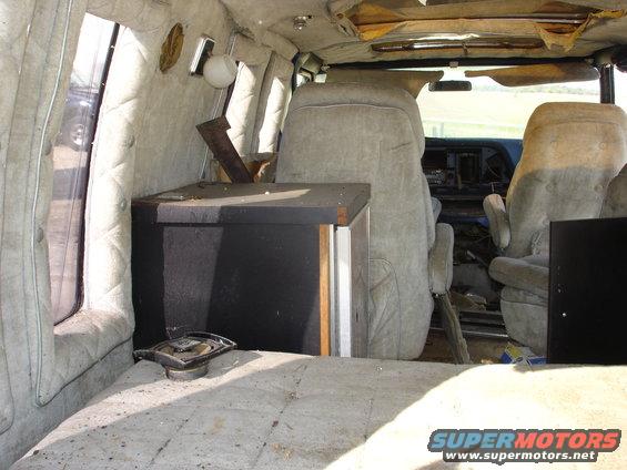 Interior view of a van with upholstered seats and paneling