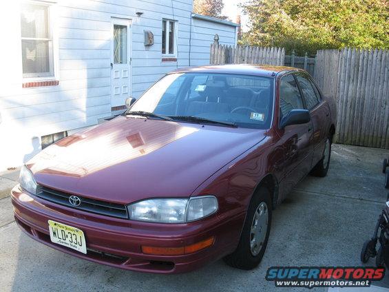 Maroon 1994 Toyota Camry sedan parked in driveway, front 3/4 view