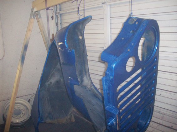 Blue Jeep CJ5 grille and fender hanging, freshly painted