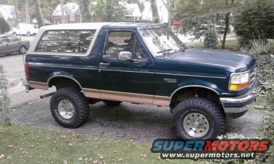 Dark green Ford Bronco with a white top, lifted on off-road tires