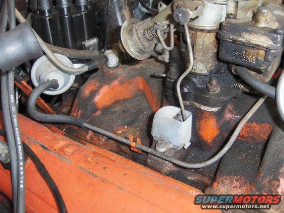 Close-up of engine components including a carburetor, distributor, and vacuum lines