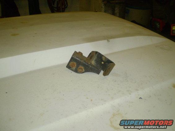 Metal bracket with three bolts on a white surface