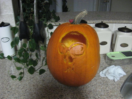 Carved pumpkin with a skull face design on a kitchen counter