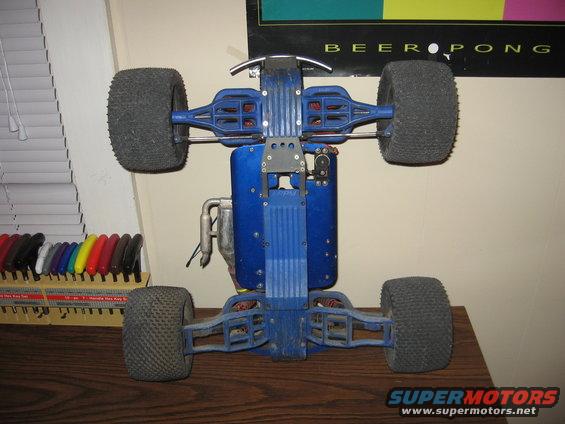 Blue remote control car chassis with large tires, viewed from below