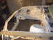 1995 Ford Taurus - The bare metal chassis of a car is visible, undergoing restoration or repair work.