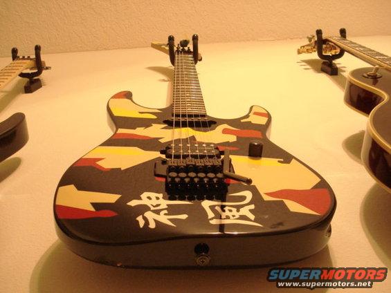 Electric guitar with camouflage pattern and Japanese characters