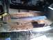 1969 Ford Mustang - A power tool is used to address severe rust damage on a car's floor pan during a restoration project.