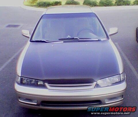Front view of a gold and dark gray car with a dark hood