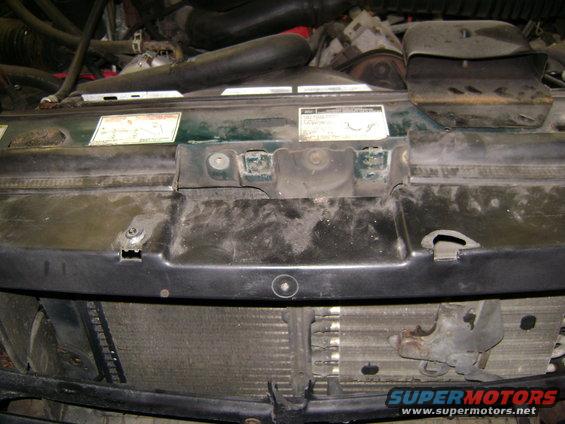 Close-up of a vehicle's engine bay, showing the radiator and some hoses