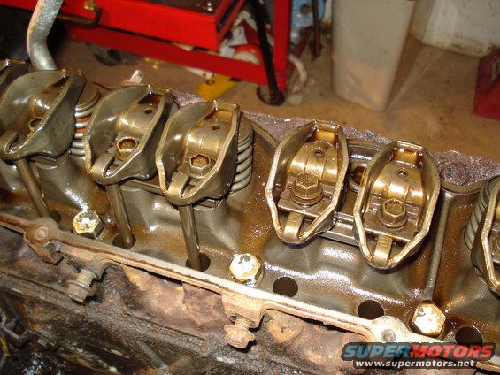 Close-up of engine valve train components, including rocker arms and pushrods, in an engine block