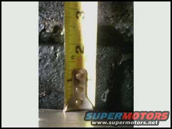 Measuring tape against a dark, textured surface, showing inches