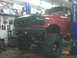 1994 Ford F-250 - This red Ford truck, likely from the early 1990s, is undergoing modifications in a workshop.
