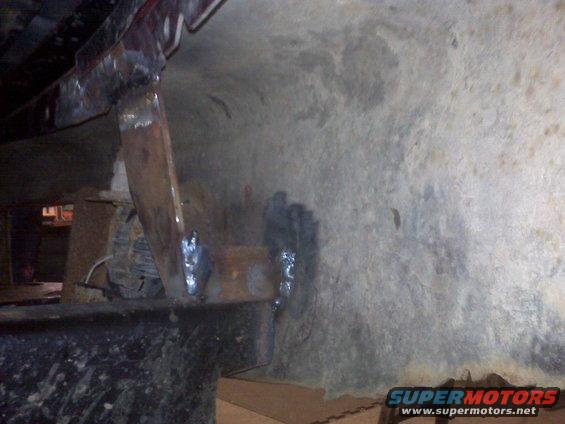 Undercarriage repair with visible welds and metal brackets